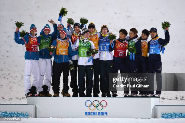 Silver medalists Austria, gold medalists Germany and bronze medalists Japan celebrate during the flower ceremony for the Men's Team Ski Jumping final...