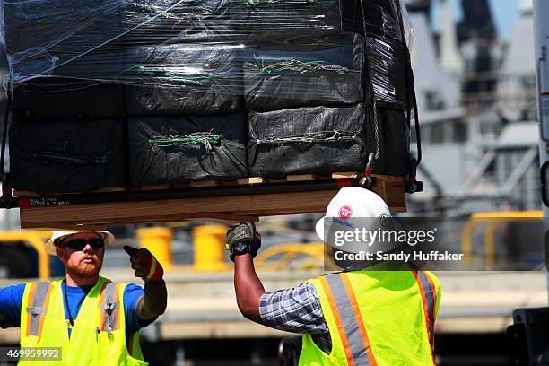 Confiscated bails of cocaine are unloaded from the USS Boutwell on April 16, 2015 at Naval Base San Diego in San Diego, California. Officials from...