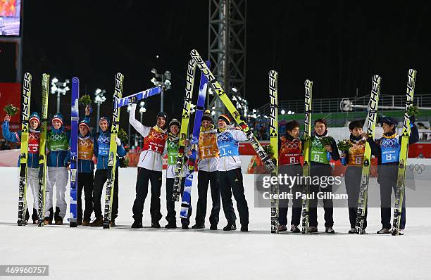 Silver medalists Austria, gold medalists Germany and bronze medalists Japan celebrate during the flower ceremony for the Men's Team Ski Jumping final...