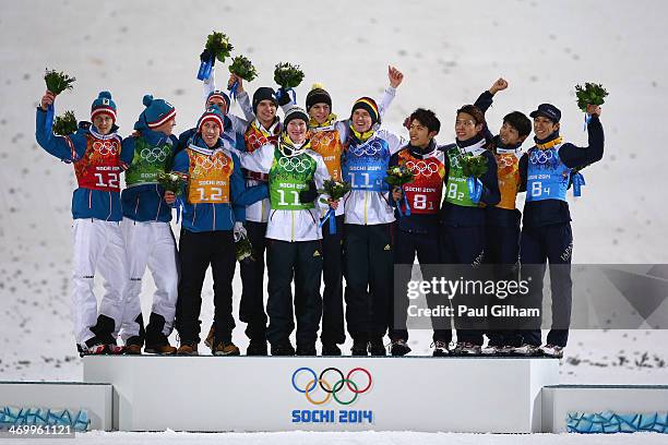 Silver medalists Austria, gold medalists Germany and bronze medalists Japan celebrate during the flower ceremony for the Men's Team Ski Jumping final...