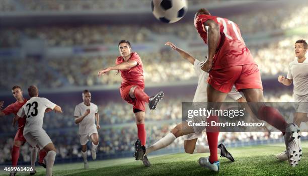 soccer player kicking ball in stadium - football players stock pictures, royalty-free photos & images