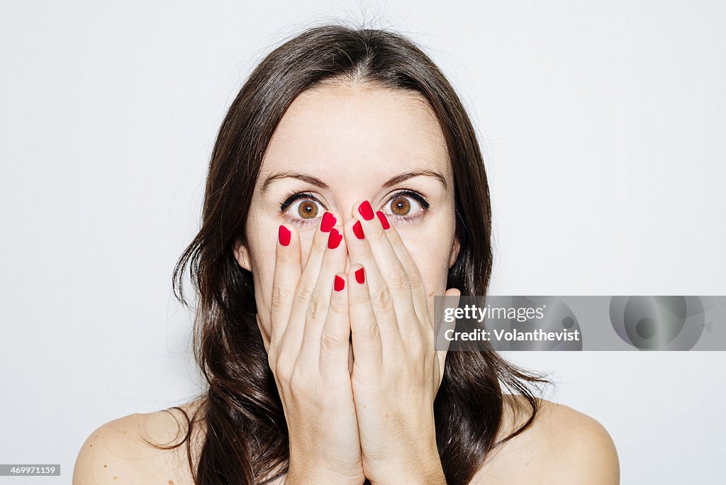 Beautiful woman with hands on face and red nails