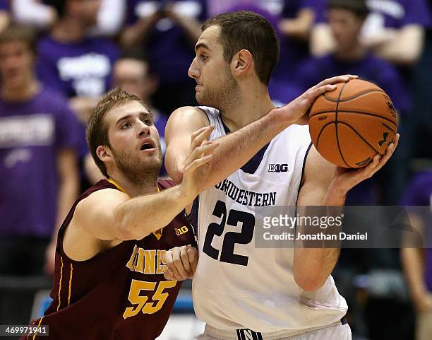 Elliott Eliason of the Minnesota Golden Gophers defends against Alex Olah of the Northwestern Wildcats at Welsh-Ryan Arena on February 16, 2014 in...