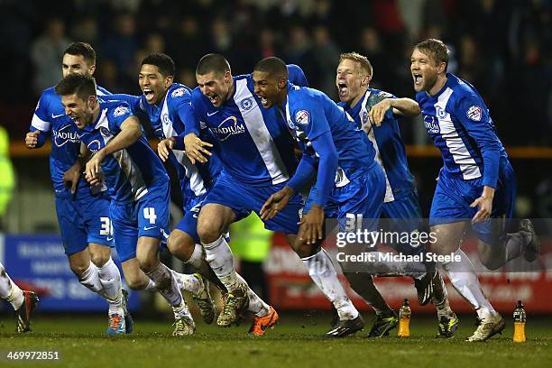 The Peterborough United players celebrate their 4-3 win on penalties after Tommy Rowe converted the winning penalty during the Johnstone's Paint...