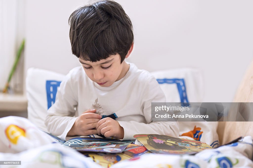 Boy reading book in bed