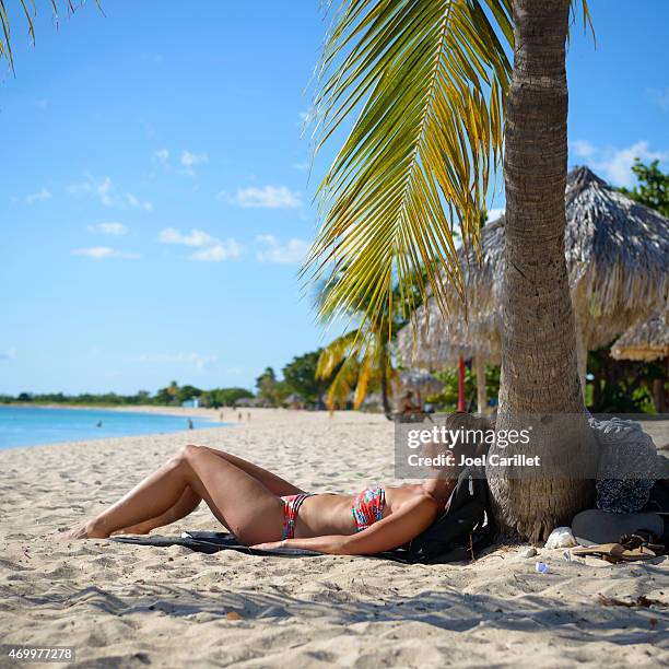 frau besuch in kuba sonnenbaden am strand in playa ancon - playa ancon cuba stock-fotos und bilder