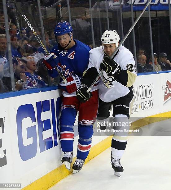 Derek Stepan of the New York Rangers is checke dinto the boards by Daniel Winnik of the Pittsburgh Penguins during the second period in Game One of...