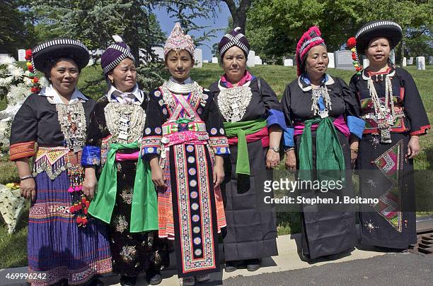 Hmong women in traditional garb, stand for photos after a wreath laying ceremony at the Lao Veterans Memorial Monument at Arlington National Cemetery...