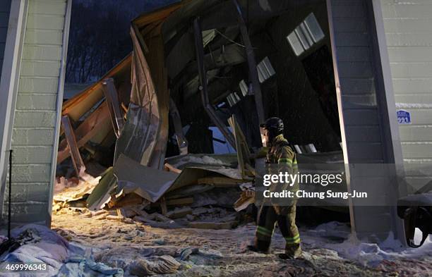 Rescue workers search for survivors from a collapsed resort gymnasium on February 18, 2014 in Gyeongju, South Korea. A resort building in the...