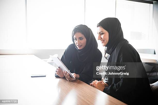 emirati arabische geschäftsfrauen mit tablet pc - emirati at work stock-fotos und bilder