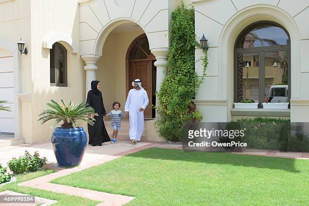 young arabic family leaving their luxury dubai villa - arab villa stockfoto's en -beelden