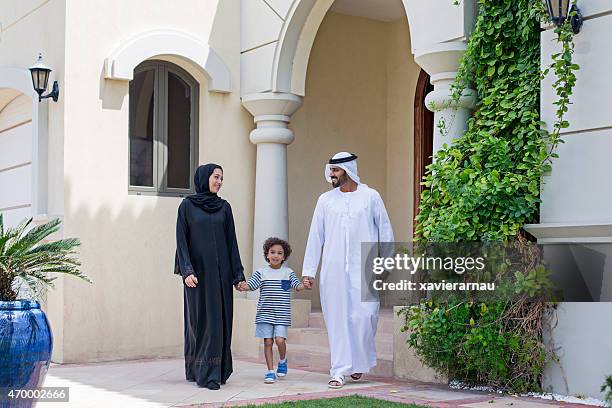 arab familia caminando en frente de su casa - etnias de oriente medio fotografías e imágenes de stock