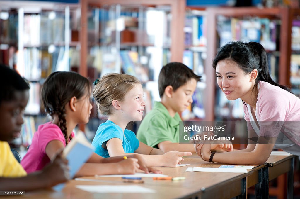 Teacher Helping Students in Classroom