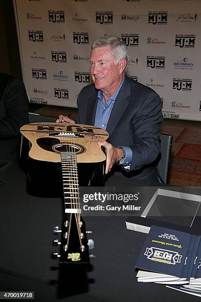 Mack Brown signs a charity auction guitar backstage during the Mack, Jack & McConaughey charity gala at ACL Live on April 16, 2015 in Austin, Texas.