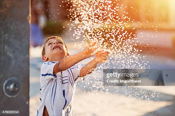 kleine junge spaß im wasser park fountain - hands fountain water stock-fotos und bilder