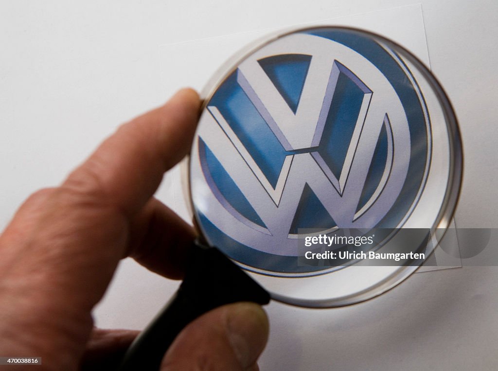 Magnifying glass with logo Volkswagen AG.