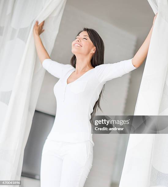 peaceful woman at home opening the window - fresh breath stockfoto's en -beelden