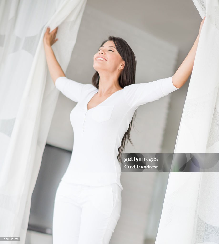 Peaceful woman at home opening the window