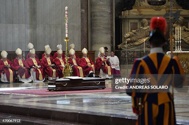 Cadinals sit in front of the coffin of Cardinal Roberto Tucci during his funeral at St Peter's basilica on April 17, 2015 at the Vatican. AFP PHOTO /...