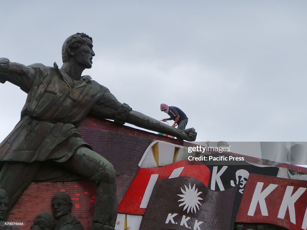 A man cleaning the mural of Philippine hero, Andress...