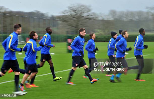 Arsenal's French striker Olivier Giroud and players warm up during a training session at Arsenal's training ground at London Colney, north of London...