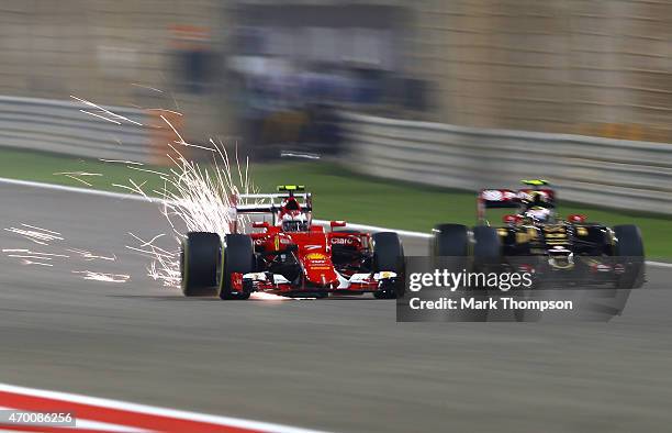 Kimi Raikkonen of Finland and Ferrari and Pastor Maldonado of Venezuela and Lotus drive during practice for the Bahrain Formula One Grand Prix at...