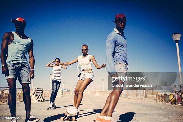 cool african american teenagers longboarding at the beach - woman longboard stock pictures, royalty-free photos & images