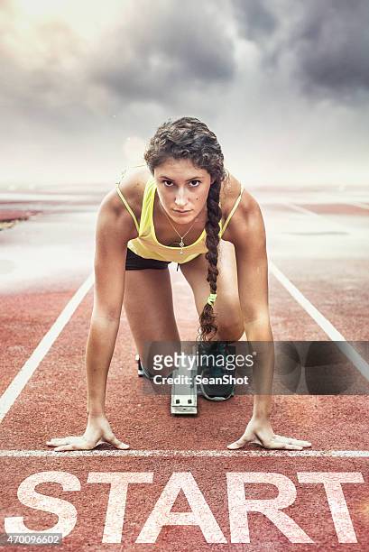 female athlete with yellow too in the starting blocks - forward athlete stockfoto's en -beelden
