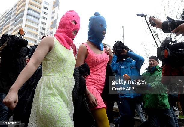 Wearing masks members of Russian punk group Pussy Riot, Nadezhda Tolokonnikova and Maria Alyokhina walk in front of journalists while leaving the...