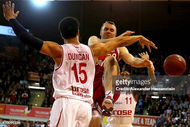 Dusko Savanovic of Muenchen is challenged by Joshua Duncan of Bamberg and his team mate Bradley Wanamaker during the Beko Basketball Bundesliga match...