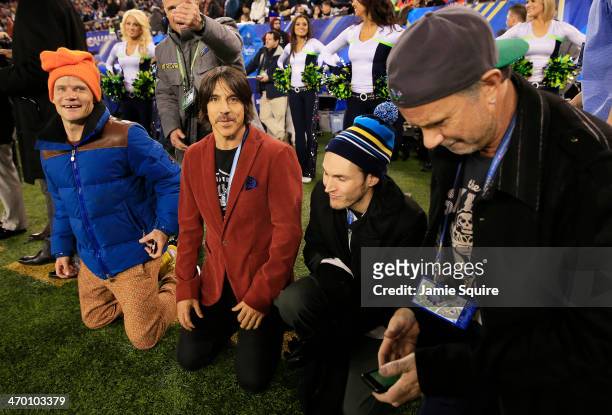 The Red Hot Chili Peppers watch Super Bowl XLVIII between the Denver Broncos and the Seattle Seahawks from the sidelines at MetLife Stadium on...