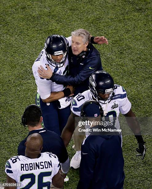 Quarterback Russell Wilson of the Seattle Seahawks talks with head coach Pete Carroll of the Seattle Seahawks as he comes off field during Super Bowl...