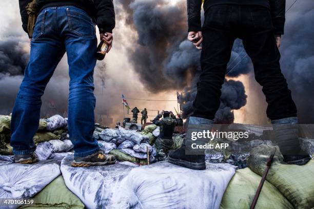 Anti-government demonstrators stand on barricades during clashes with riot police in Kiev on February 18, 2014. Opposition leader Vitali Klitschko on...