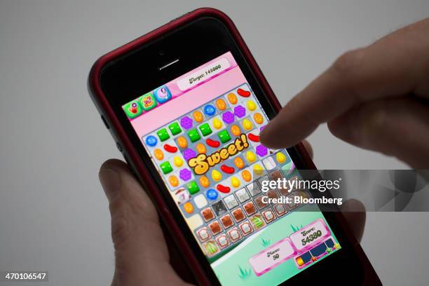 User plays the "Candy Crush Saga" puzzle game on an Apple.Inc iPhone 5 on in this arranged photograph in London, U.K., on Tuesday, Feb. 18, 2014....