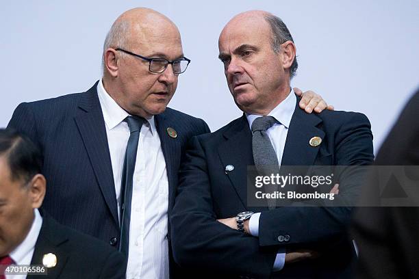 Michel Sapin, France's finance minister, left, talks to Luis de Guindos, Spain's economy minister, during a Group of 20 finance ministers' and...