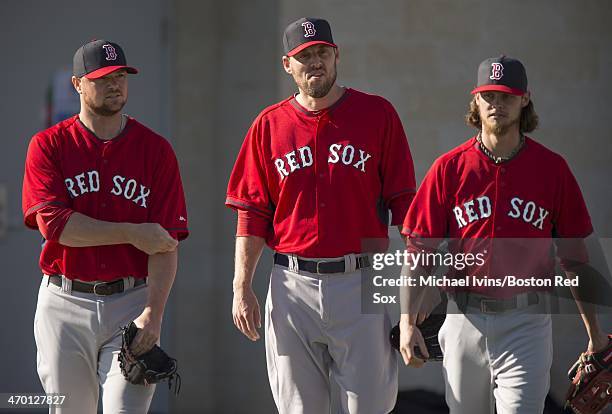 Pitchers Jon Lester, John Lackey and Clay Buchholz of the Boston Red Sox take the field before the start of a Spring Training workout at Fenway South...