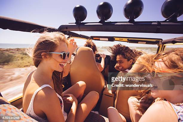 afro mädchen lachen mit freunden auf reisen urlaub - girls driving a car stock-fotos und bilder