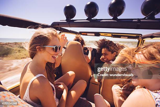 afro girl laughing with friends on a road trip vacation - car young driver stockfoto's en -beelden