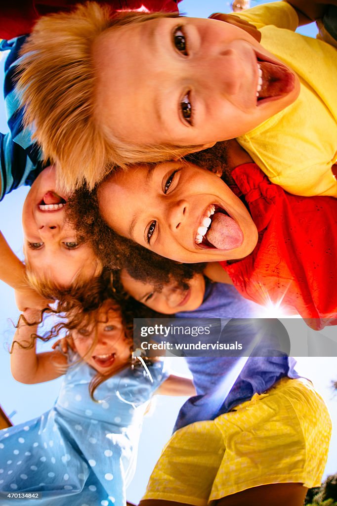 Multiethniques enfants posant souriant à la caméra au-dessus de la porte
