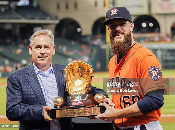 Dallas Keuchel of the Houston Astros receives his Rawlings Gold Glove Award from Mike Falby of Rawlings at Minute Maid Park on April 17, 2015 in...