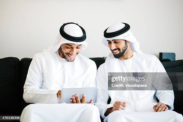arab men with digital tablet - middle east friends stock pictures, royalty-free photos & images