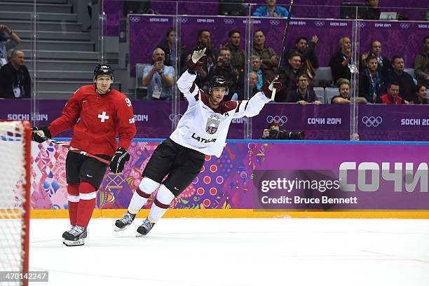 Lauris Darzins of Latvia celebrates after scoring an open net goal late in the third period against Switzerland during the Men's Ice Hockey...