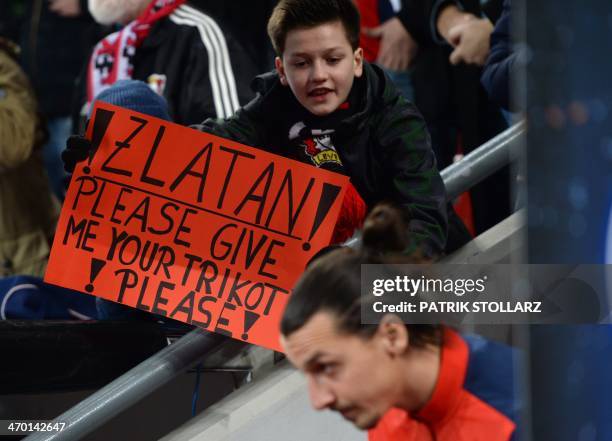 Paris Saint-Germain's Swedish forward Zlatan Ibrahimovic passes by a banner prior to the first-leg round of 16 UEFA Champions League football match...