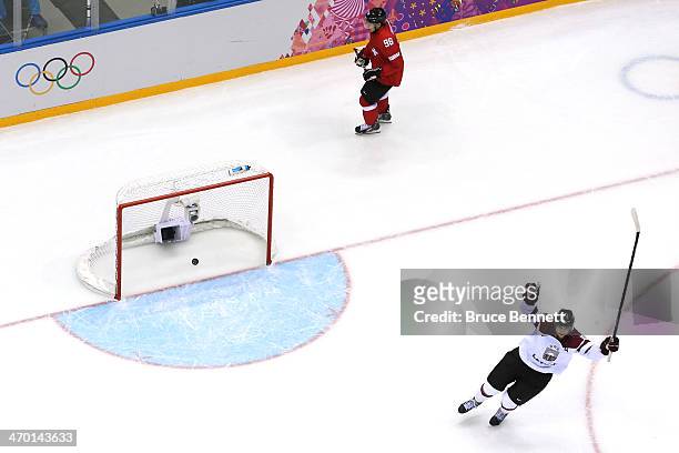 Lauris Darzins of Latvia celebrates an open net goal late in the third period against Switzerland during the Men's Ice Hockey Qualification Playoff...