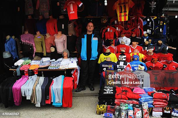 Man stands in a shop selling soccer shirts of all nationalities and Kosovo shirts in a market place the day after the parade for the sixth...