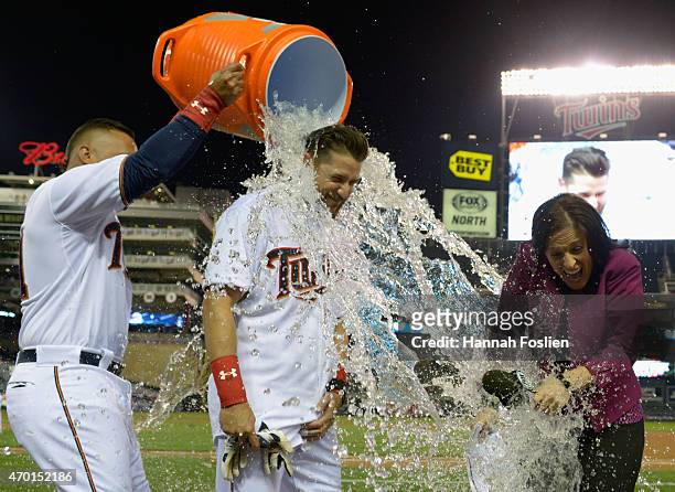 Oswaldo Arcia of the Minnesota Twins pours ice water on teammate Trevor Plouffe and tv reporter Marney Gellner after Plouffe hit a walk-off solo home...