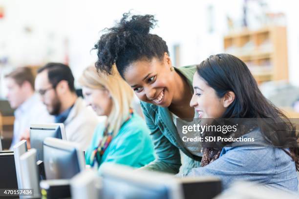 diverse college students using computers in library or computer lab - computer lab stock pictures, royalty-free photos & images