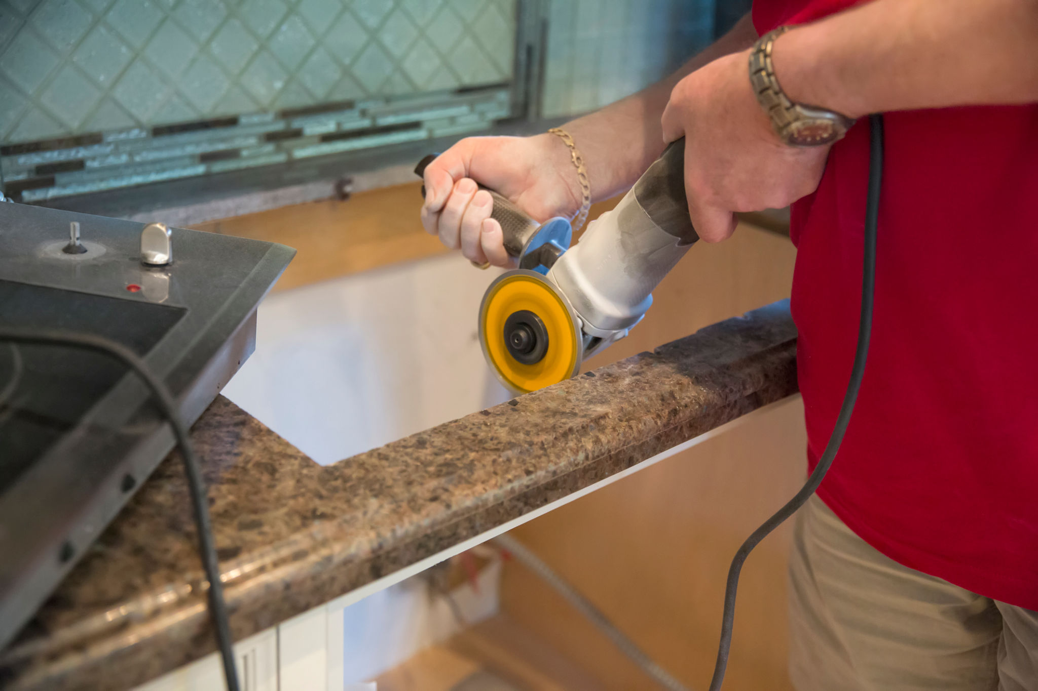 Man cuts granite for installing range top in home Man cuts granite for installing range top in home