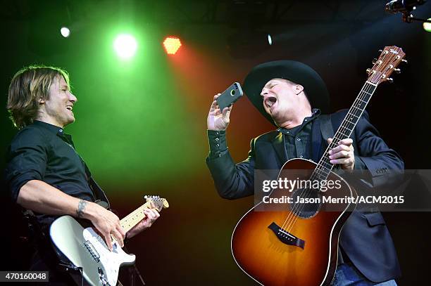 Recording artist Keith Urban and and host Garth Brooks pose for a selfie photo onstage during the ACM Lifting Lives Gala at the Omni Hotel on April...