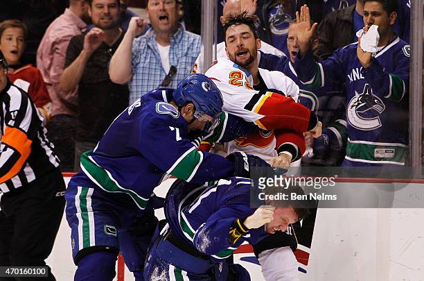 Deryk Engelland of the Calgary Flames fights with Dan Hamhuis and Derek Dorsett of the Vancouver Canucks during Game Two of the Western Conference...